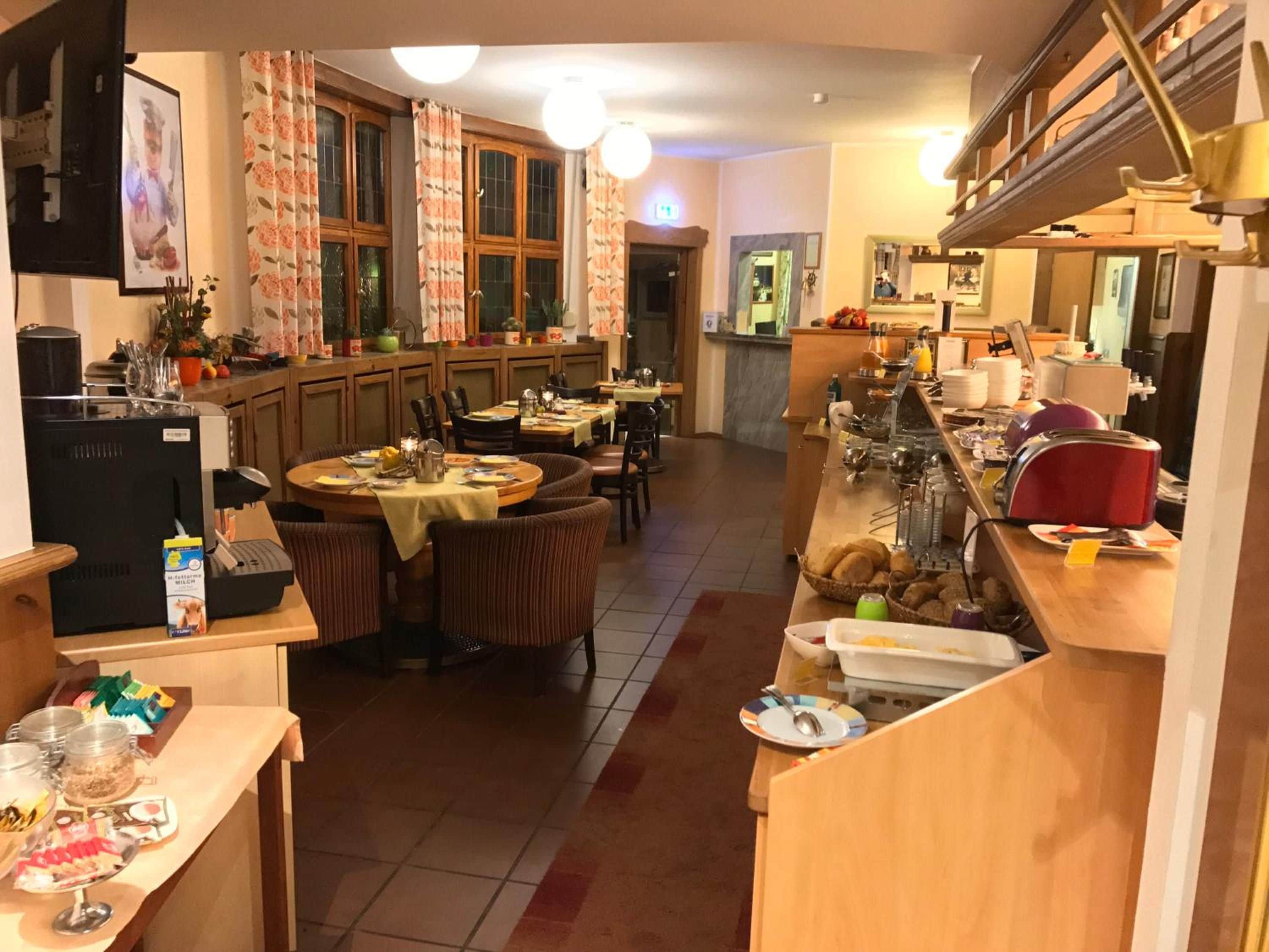 Un comedor de hotel con varias mesas, sillas y una mesa de buffet.