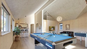 A pool table in a room with wooden walls, a bar area, and a hanging light fixture. - 7 bedroom lovely home in Frederiksværk (Frederiksværk)