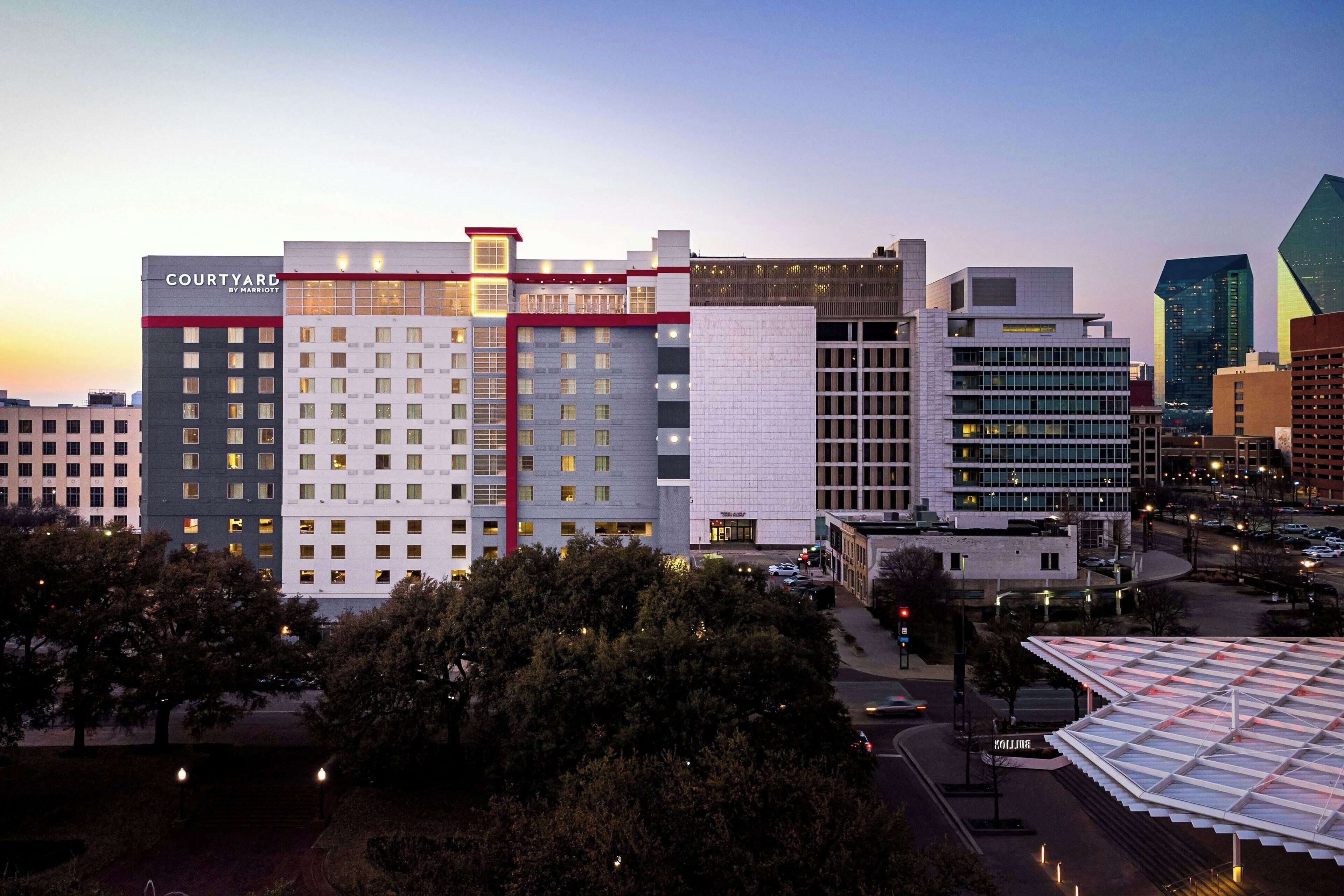 A hotel with multiple floors, a prominent red and white facade, and a modern architectural design.