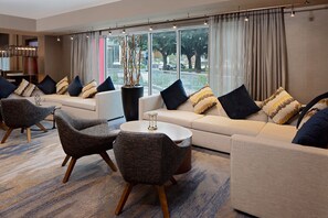 Una sala de estar moderna con un sofá, sillones y una mesa de centro.