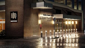 A brick building with a sign for 'HQ COURTYARD' and a 'ROOFTOP BAR'. - Courtyard by Marriott Dallas Downtown/Reunion District (Dallas)