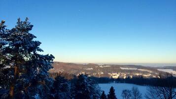 Ein weitreichender Blick auf eine verschneite Landschaft bei strahlendem Himmel.