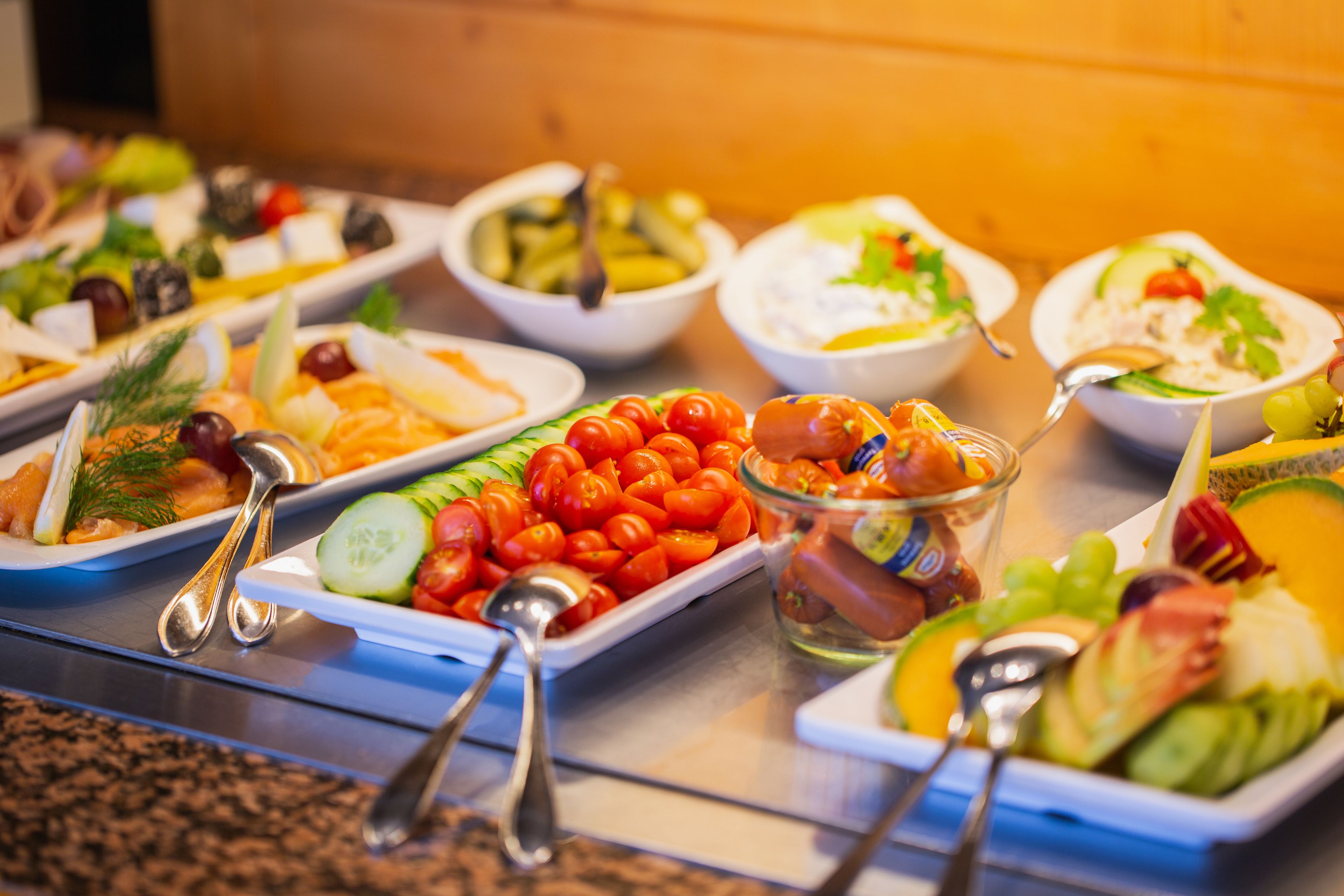 Un buffet proposant une variété de plats, notamment des salades, des fruits et des légumes.