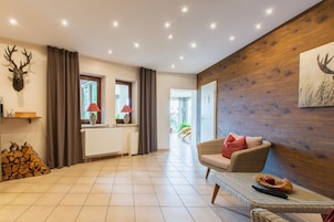 A spacious living area with a fireplace, a large window, and a wall-mounted deer head decoration.