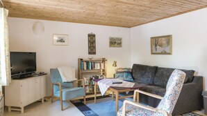 A living room with a television, bookshelves, a sofa, and a coffee table.