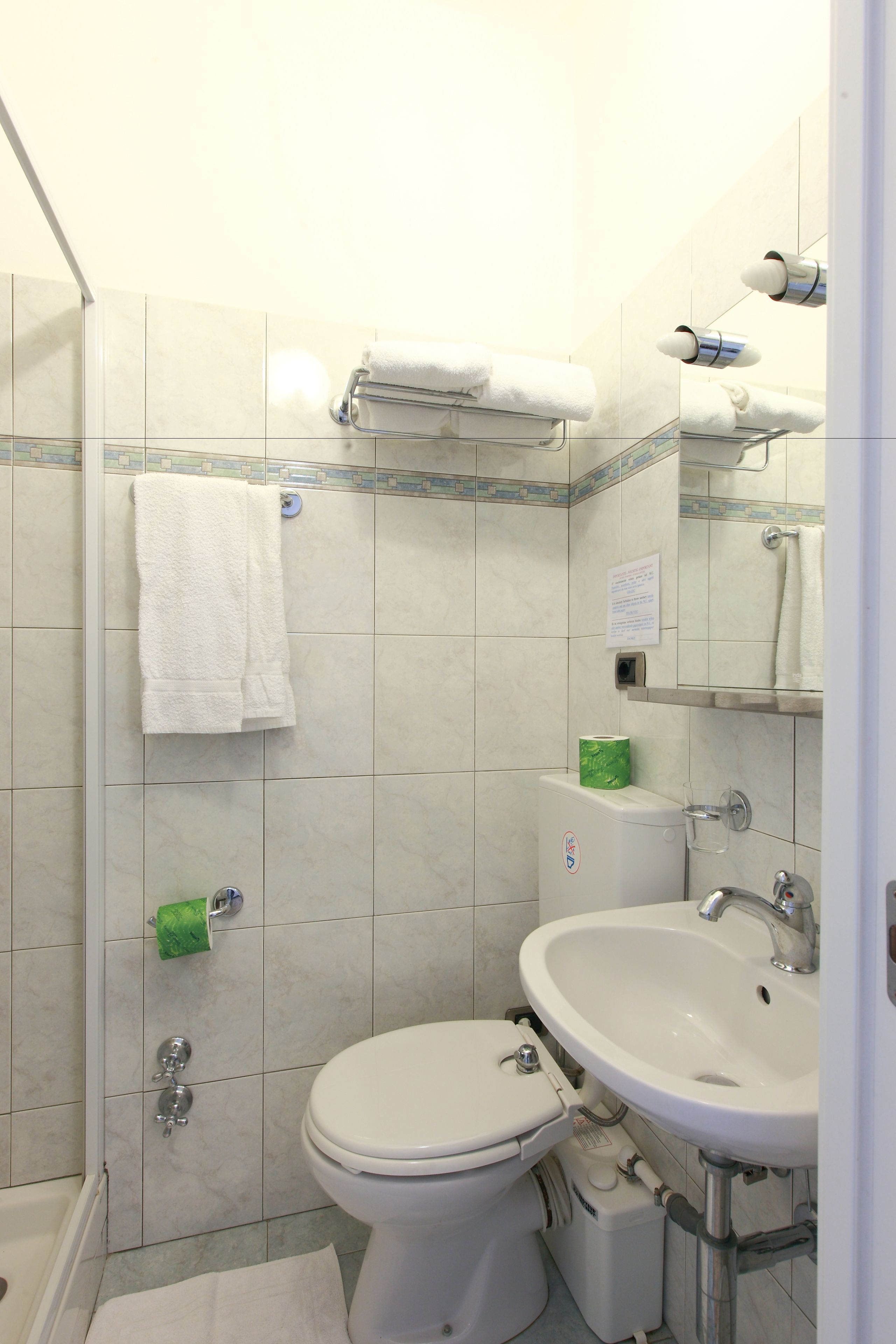 A bathroom with a toilet, sink, and towel rack.