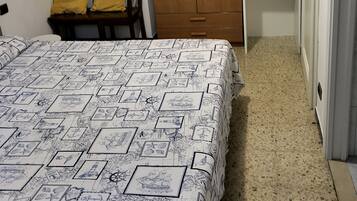 Un dormitorio con una cama, un armario de madera, un escritorio y una silla.