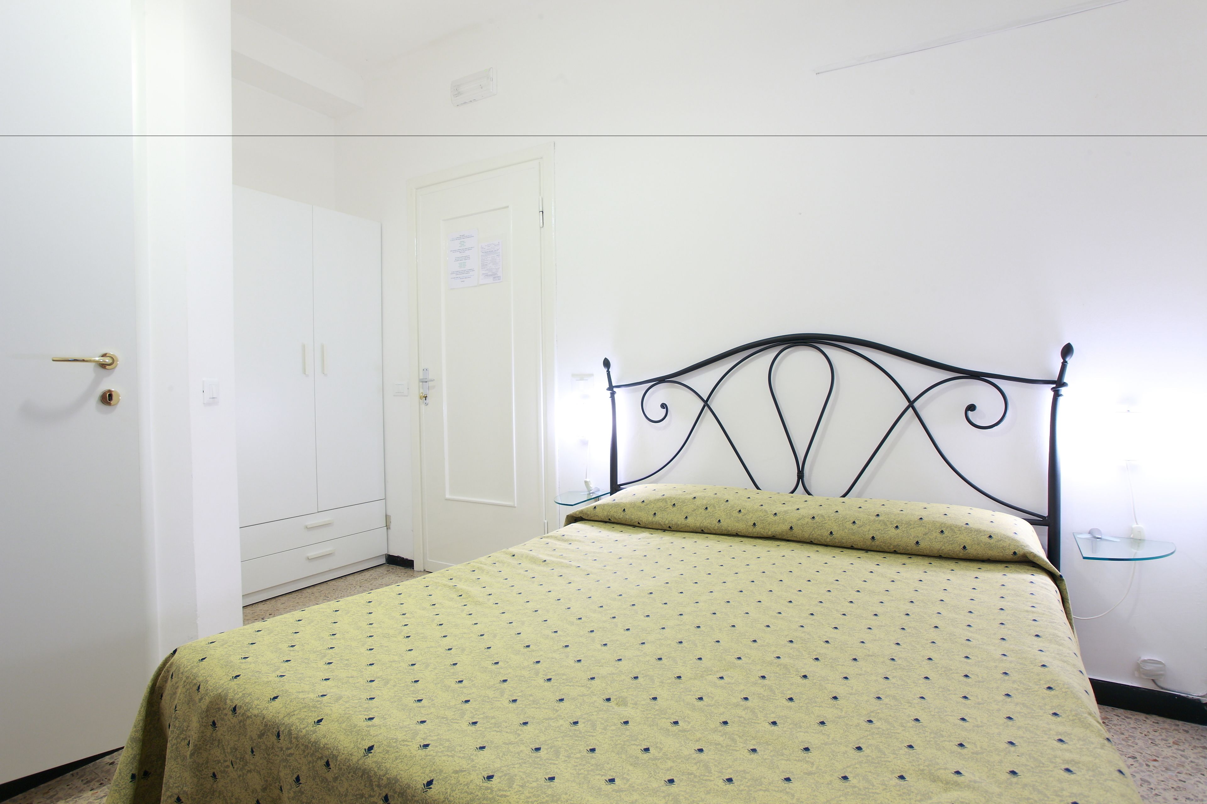 Una habitación con una cama, un armario y una puerta.