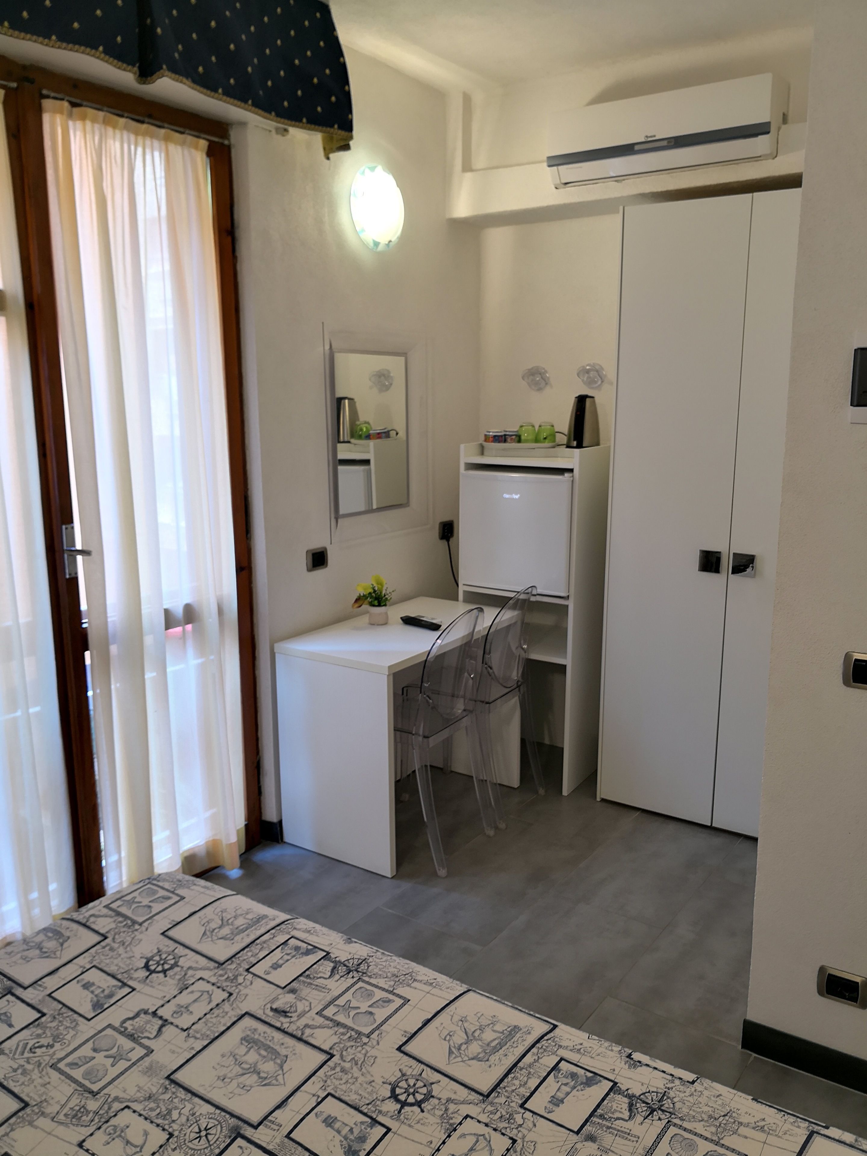 A compact room with a bed, a desk, and a wardrobe.