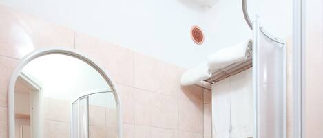 Un bagno con lavandino, WC e doccia.