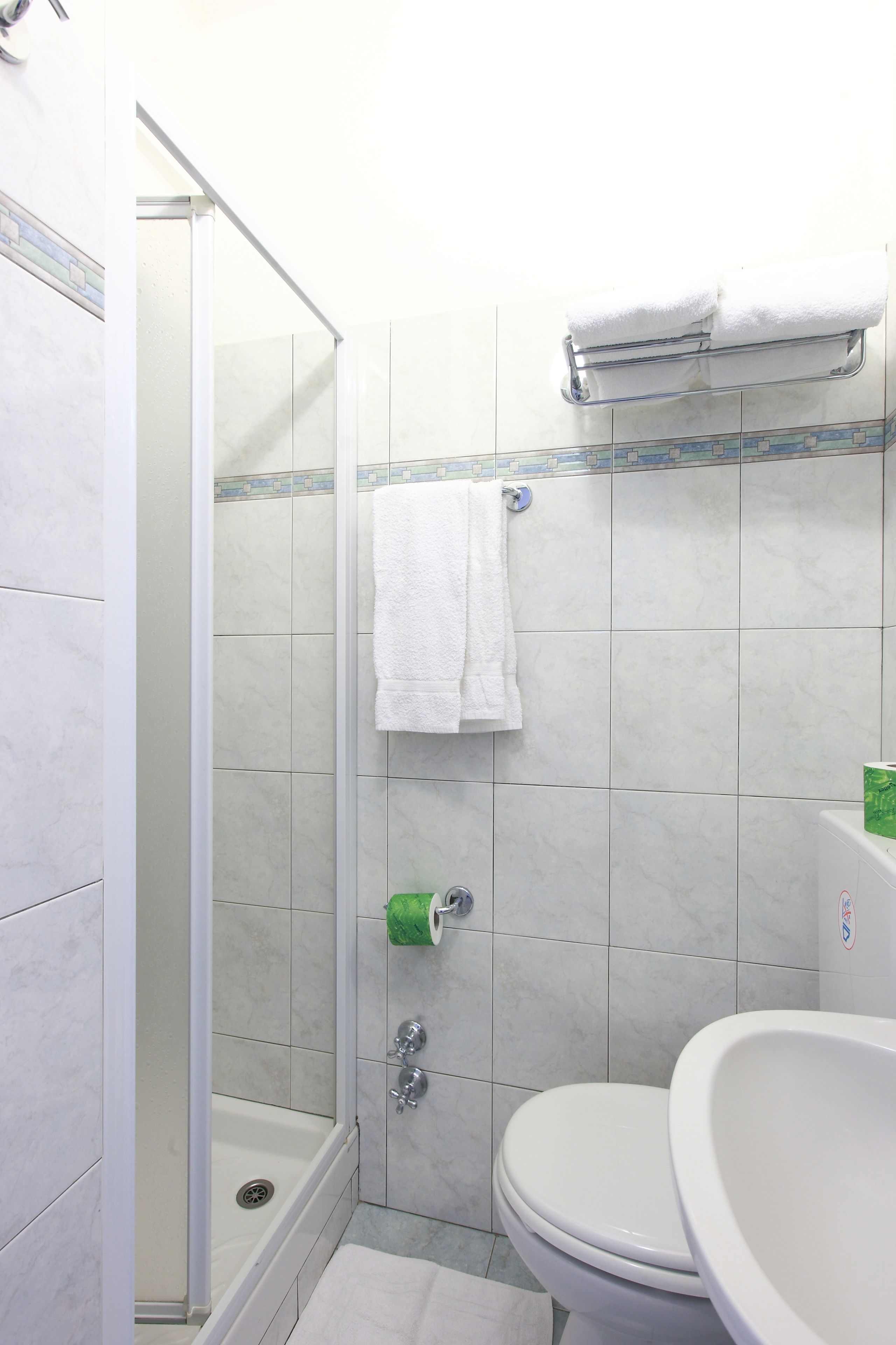 A bathroom with a shower, toilet, and sink.