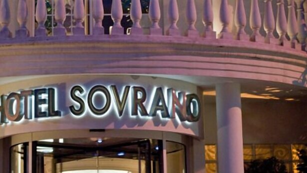 The exterior of Hotel Sovrano with a prominent sign and a circular architectural feature above the entrance. - Hotel Sovrano (Alberobello)