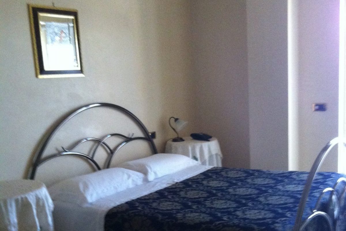 Una camera da letto con un letto, comodini e un tavolino da notte.