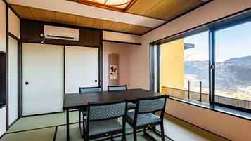 A traditional Japanese-style room with tatami flooring, a low table, and chairs.