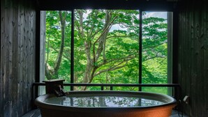 Una cabaña de madera con un ventanal grande, una bañera y un farol.