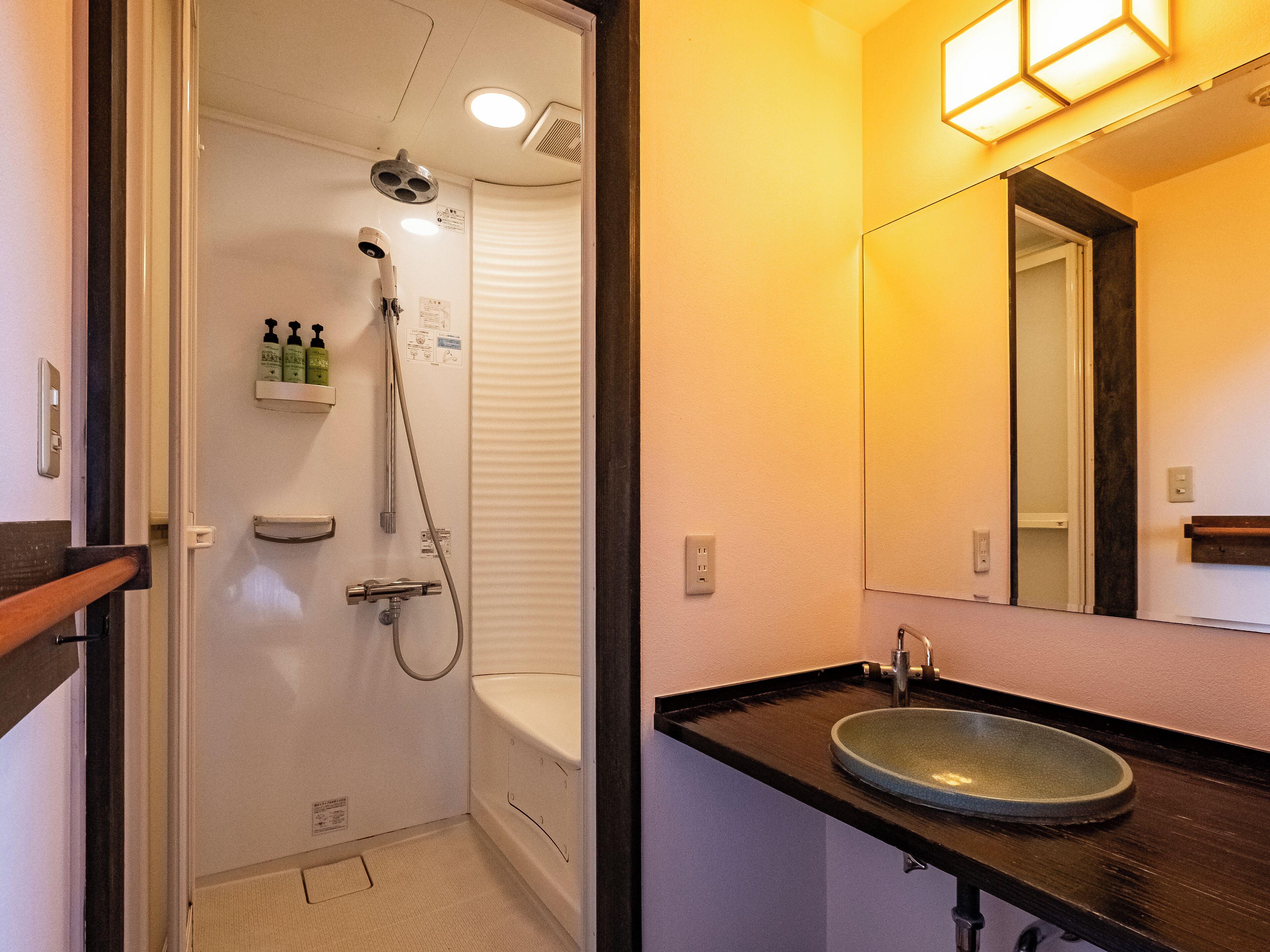 Ein Badezimmer mit Dusche, Waschbecken und Spiegel.