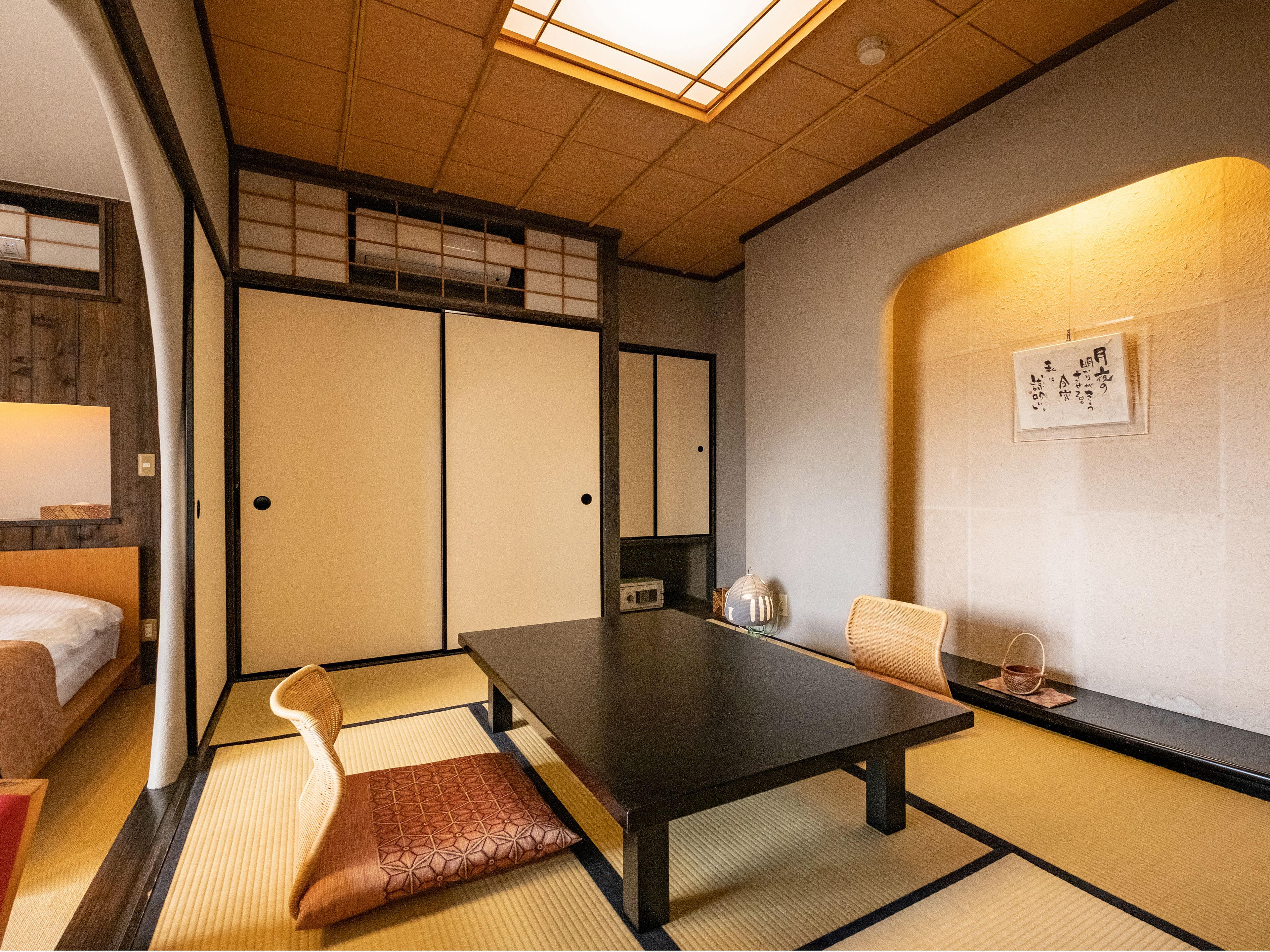 Une pièce de style japonais traditionnel, avec un sol recouvert de tatamis, une table basse et une porte coulissante.