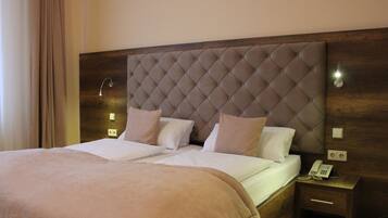 Restful retreat with a large bed featuring a tufted headboard, complete with crisp linens and two pillows.