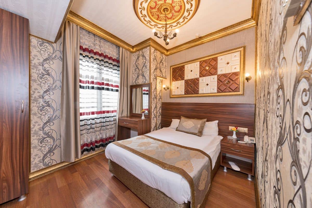 A well-appointed bedroom with a large bed, a nightstand, a dresser, and a mirror.