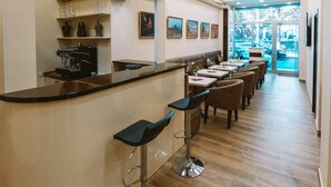 A modern restaurant with a curved counter, bar stools, and a long dining area. - L'image Art Hotel (Yerevan)