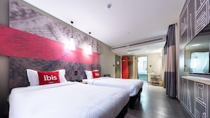 A hotel room with two beds, a red 'ibis' pillow, a marble wall, pendant lights, and a modern design. - ibis Yixing South Renmin Rd (Wuxi)