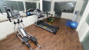 A home gym with a treadmill, elliptical, and exercise ball. - Sapphire Asta (Hyderabad)