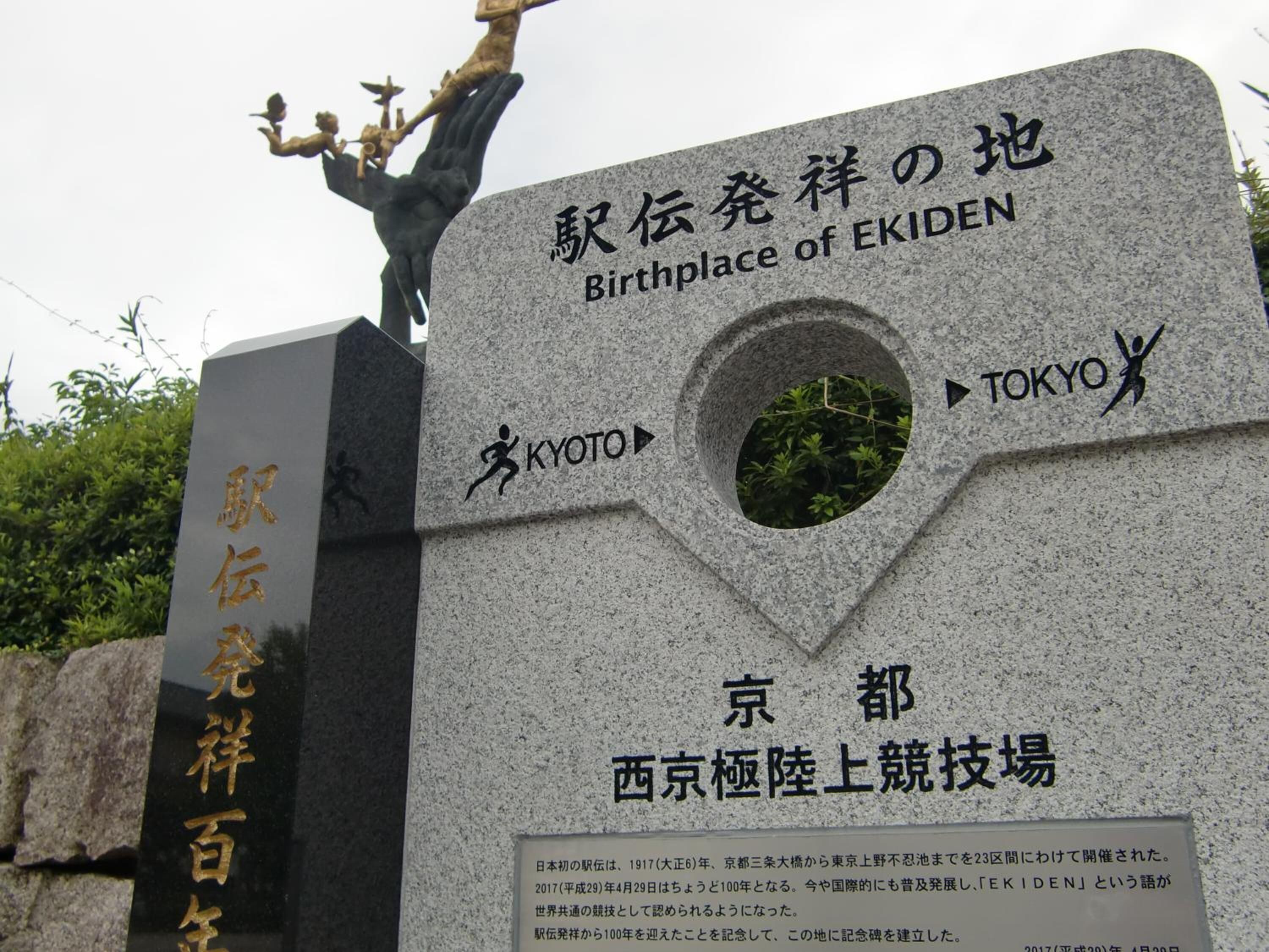 Un monumento de piedra con inscripciones y una estatua.
