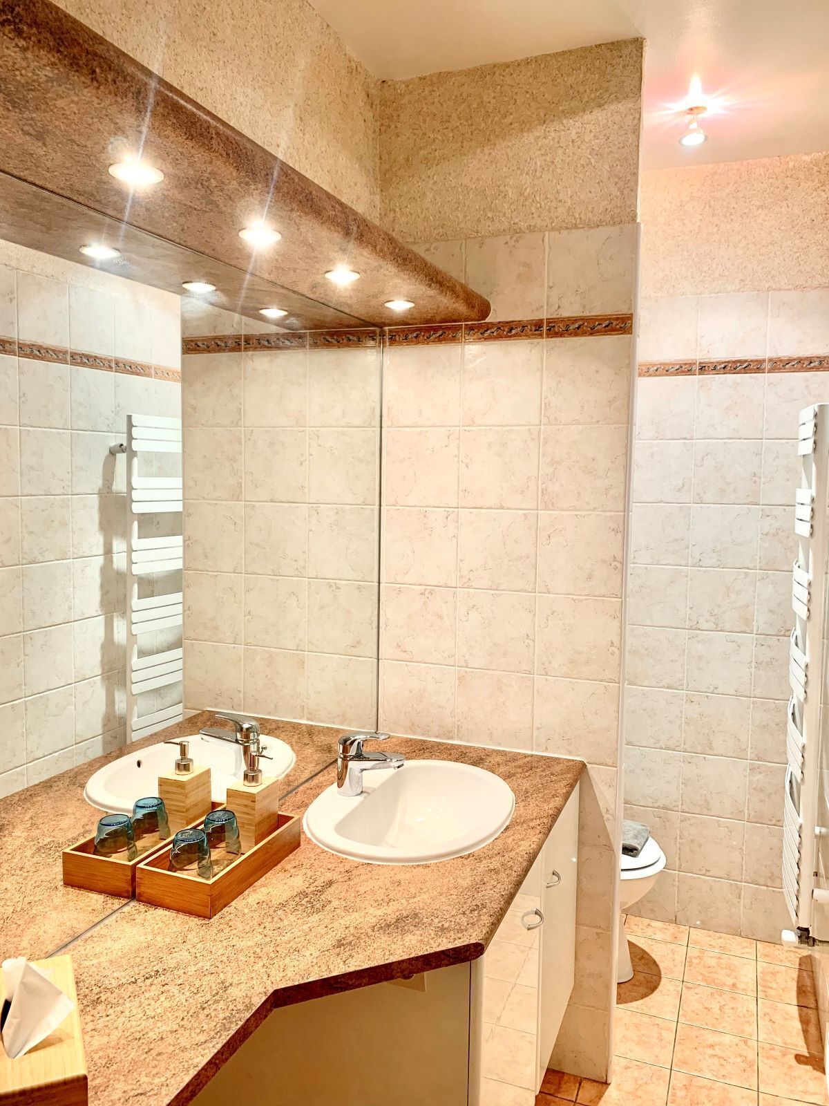 A bathroom with two sinks, a mirror, and a towel rack.
