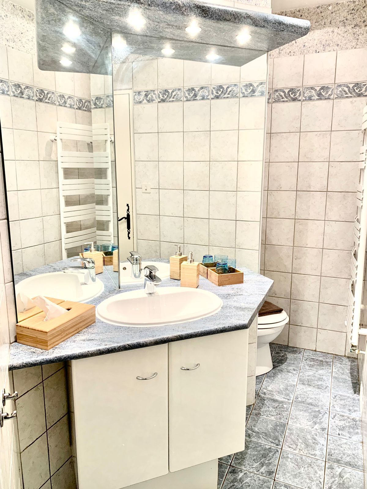 Une salle de bain avec deux lavabos, un miroir et des toilettes.
