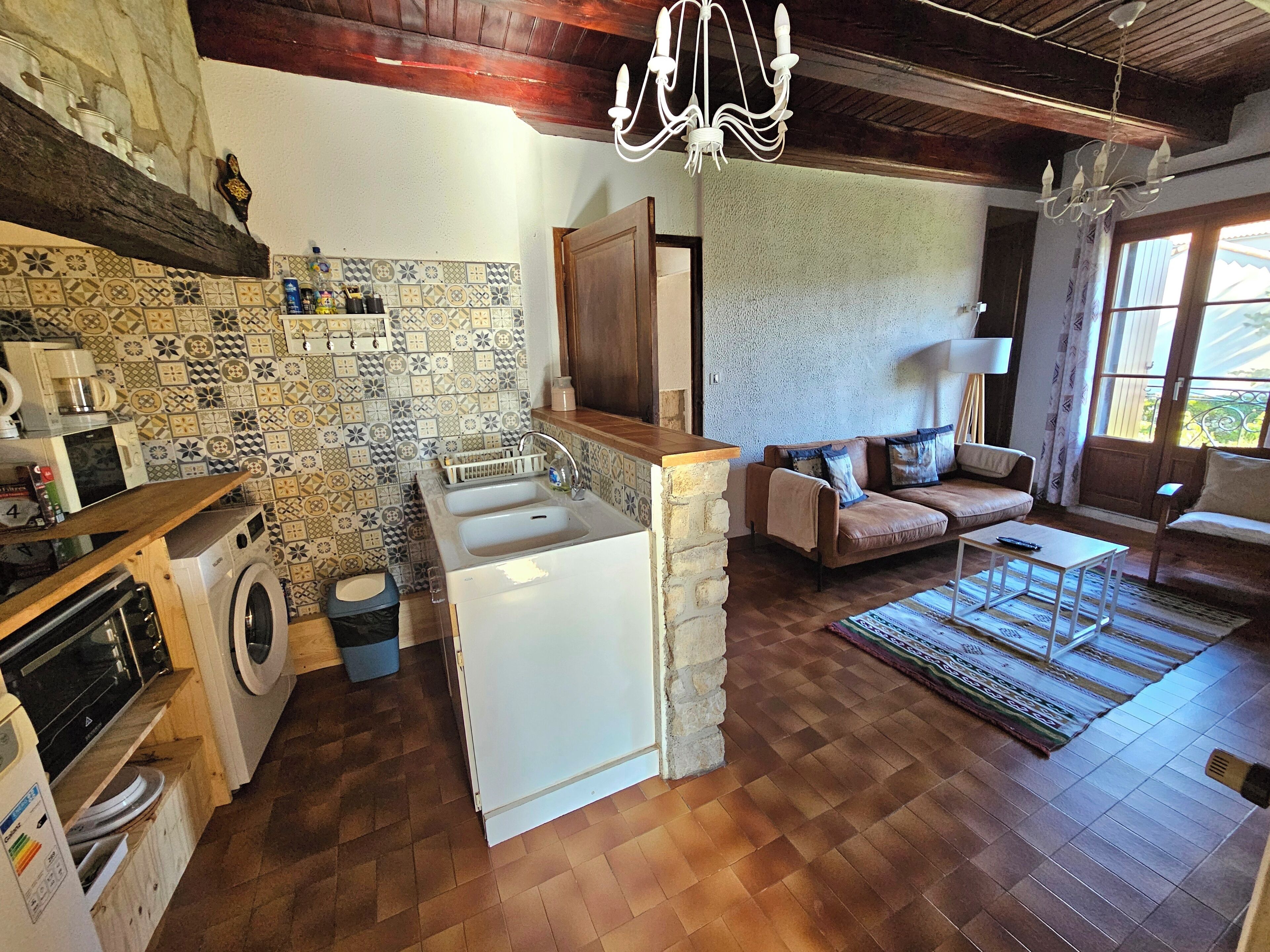 A compact kitchen with a washing machine, a sink, and a wooden countertop.