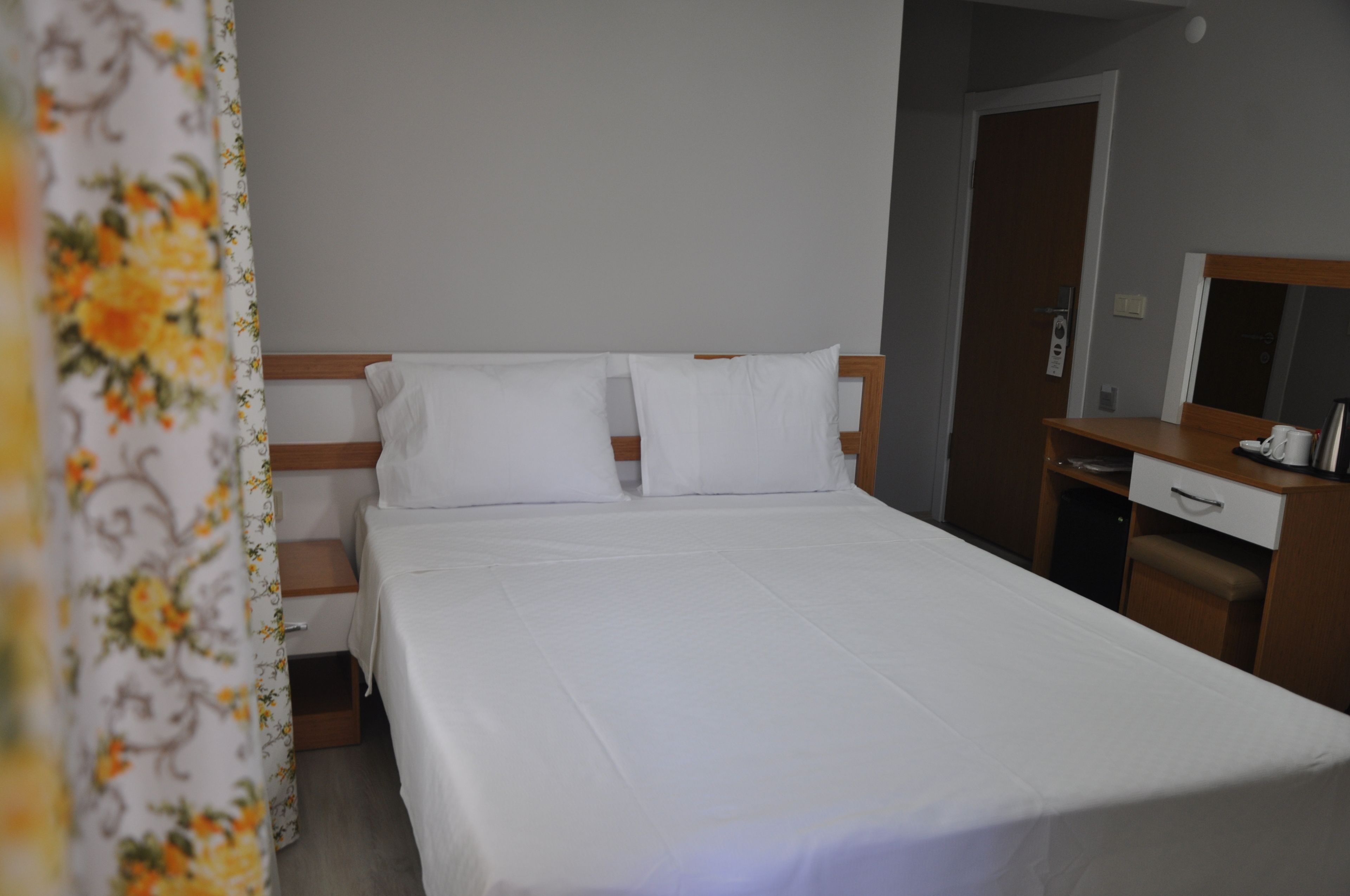Una cama bien hecha con sábanas blancas en una habitación de hotel.