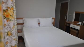 Una cama bien hecha con sábanas blancas en una habitación de hotel.