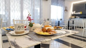 A breakfast table with a coffee mug, eggs, and pastries in a hotel room. - Hotel Ayri (Medesano)