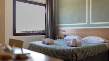 Ein Hotelzimmer mit einem Bett, einem Tisch und einem Fenster mit Blick.