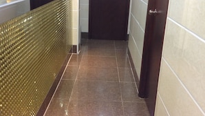 A hallway with a shiny tiled floor, a glass partition on one side, and a door labeled 'C6' on the other. - Head Sun Guest House (Kowloon)