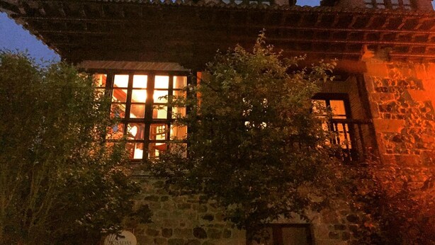 A traditional building with a large window and a stone facade.