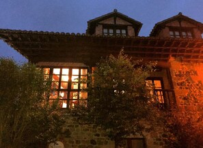 Un edificio tradicional con un amplio ventanal y fachada de piedra.