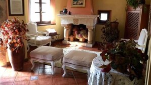 A cozy living room with a fireplace, a comfortable sofa, and a dining table.