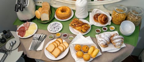 Un bufé de desayuno con diversas bollerías, pan y salsas.