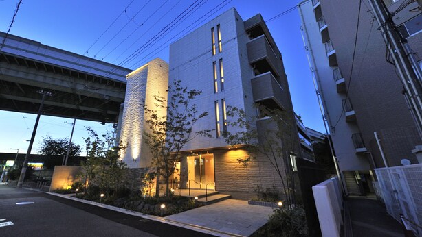 A modern building with a prominent entrance, a covered walkway, and a view of the sky. - RakutenSTAY×Shamaison Osaka Dekijima Station (Osaka)