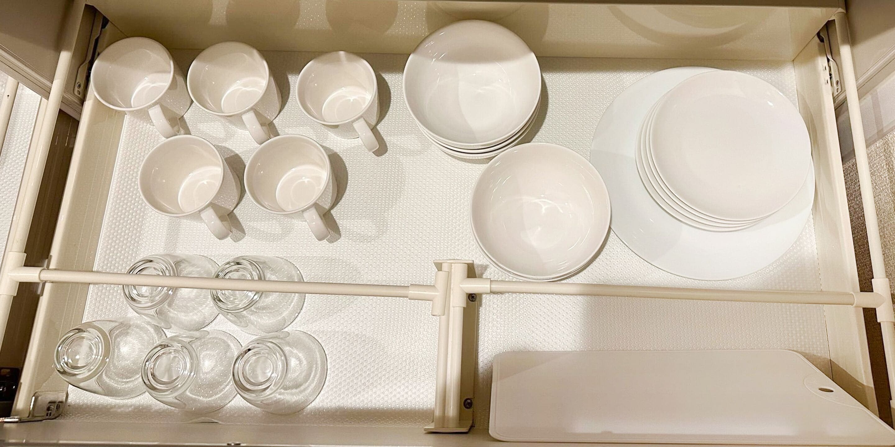A storage area with neatly arranged white dishes and glasses.