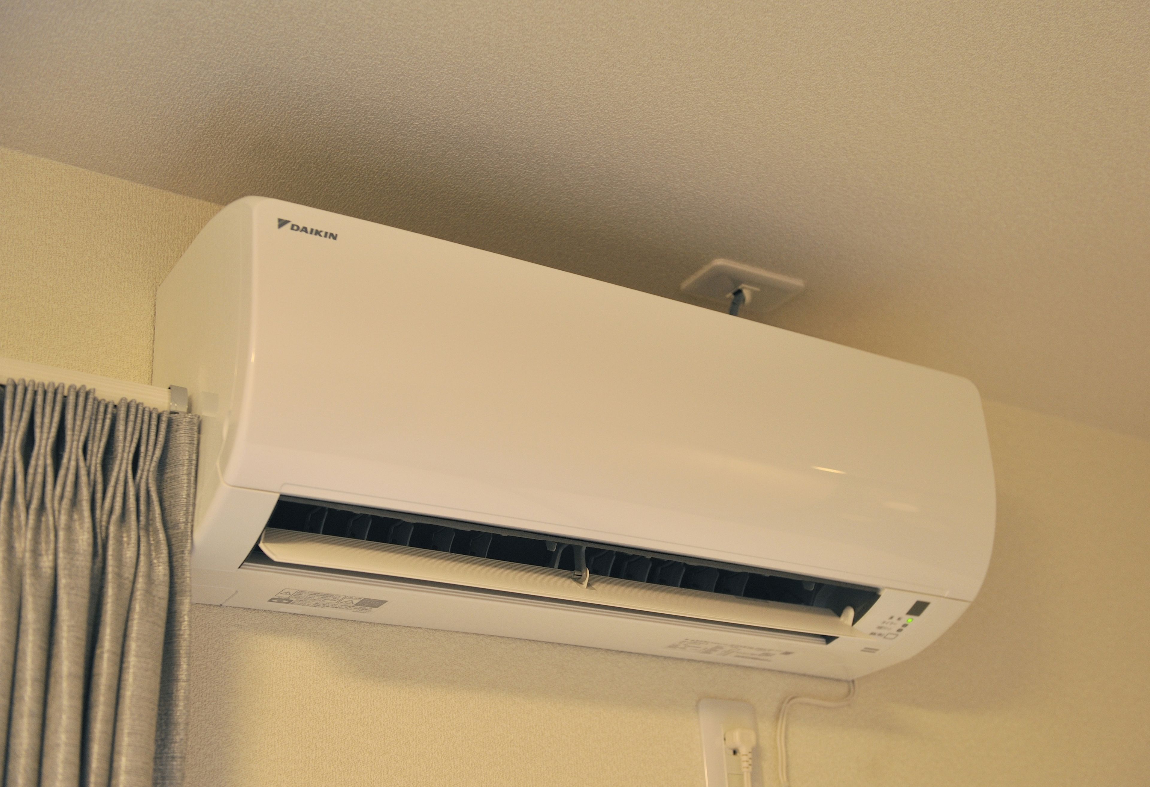 A white Daikin air conditioner unit mounted on a wall.