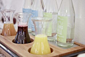 A wooden tray holding several glass bottles with labels, likely containing beverages.