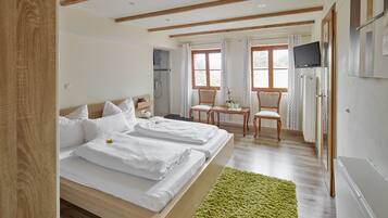 Ein Schlafzimmer mit einem Bett, einem grünen Teppich, einem Fernseher und einer Dusche.