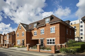A two-story residential building with a pitched roof, brick construction, and multiple windows. - Imperial Court by Viridian Apartments (Maidenhead)