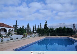 Una piscina al aire libre de temporada, sombrillas, tumbonas