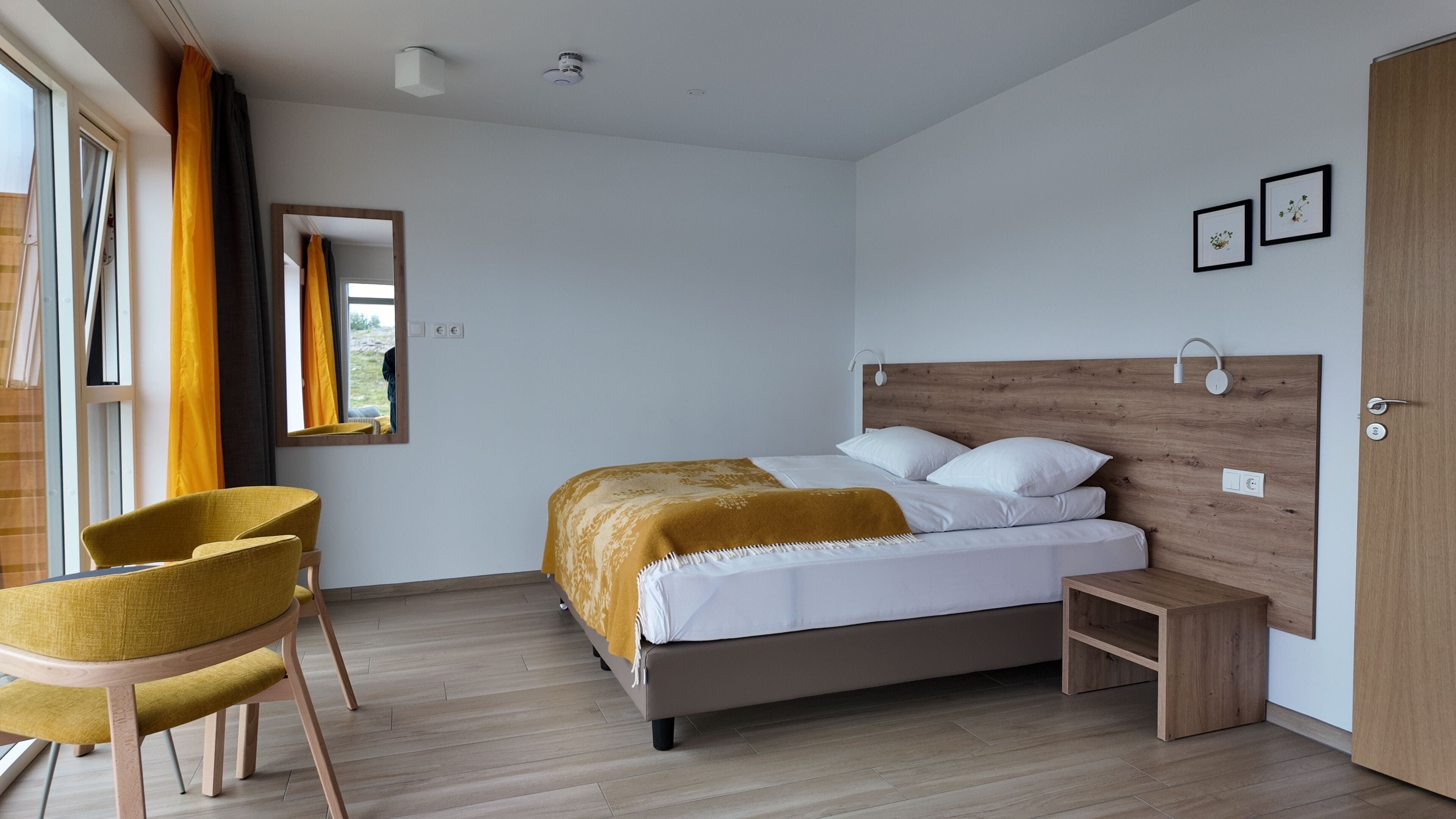 A modern bedroom with a bed, a chair, a bedside table, and a wardrobe.