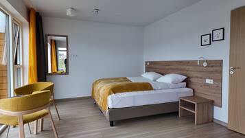 A modern bedroom with a bed, a chair, a bedside table, and a wardrobe.