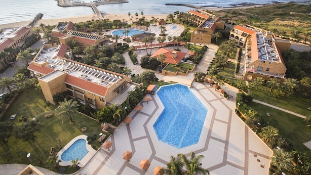 Un resort con varias piscinas, playa y vistas al océano.