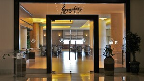 Un vestíbulo de hotel con mostrador de recepción, zona de estar y un amplio ventanal.